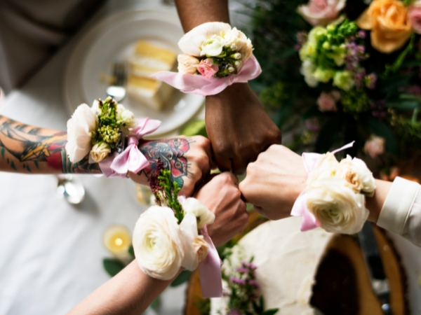 4 hands with gift at La Rosa Flower Shop